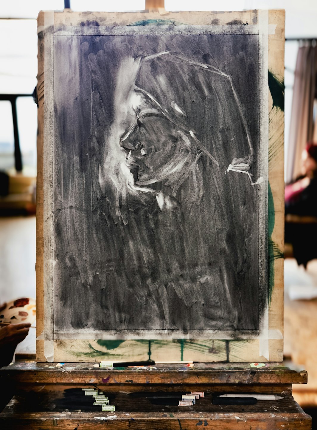 فنان يمسك لوحة أثناء العمل على رسم بورتريه.